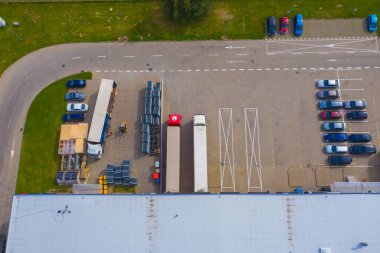 Malzeme deposunun havadan görüntüsü. Sanayi bölgesindeki lojistik merkezi yukarıdan. Lojistik merkezde yüklenen kamyonların hava görüntüsü. İnsansız hava aracından görüntüle.
