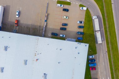 Malzeme deposunun havadan görüntüsü. Sanayi bölgesindeki lojistik merkezi yukarıdan. Lojistik merkezde yüklenen kamyonların hava görüntüsü. İnsansız hava aracından görüntüle.