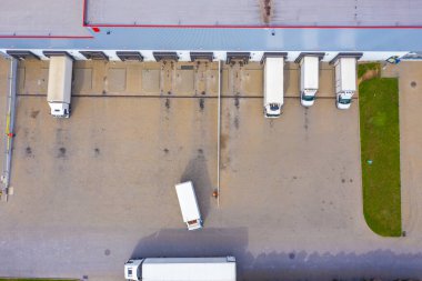 Malzeme deposunun havadan görüntüsü. Sanayi bölgesindeki lojistik merkezi yukarıdan. Lojistik merkezde yüklenen kamyonların hava görüntüsü
