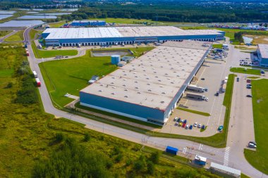 Malzeme deposunun havadan görüntüsü. Sanayi bölgesindeki lojistik merkezi yukarıdan. Lojistik merkezde yüklenen kamyonların hava görüntüsü. İnsansız hava aracından görüntüle.