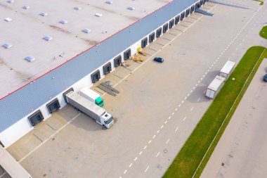 Şehir merkezindeki büyük modern sanayi deposu veya fabrika binalarının insansız hava aracı görüntüsü. Lojistik ulaşım kargo terminali.