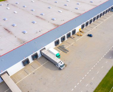 Şehir merkezindeki büyük modern sanayi deposu veya fabrika binalarının insansız hava aracı görüntüsü. Lojistik ulaşım kargo terminali.