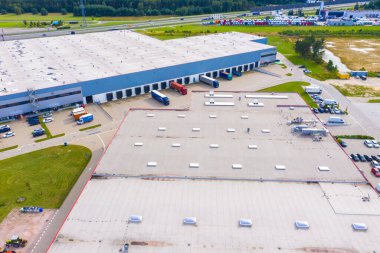 Şehir merkezindeki büyük modern sanayi deposu veya fabrika binalarının insansız hava aracı görüntüsü. Lojistik ulaşım kargo terminali.