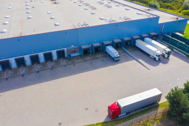 Birçok kamyonun mal indirdiği Endüstriyel Yükleme Alanının Hava Çekimi.