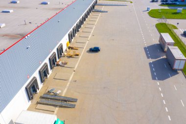 Malzeme deposunun havadan görüntüsü. Sanayi bölgesindeki lojistik merkezi yukarıdan. Lojistik merkezde yüklenen kamyonların hava görüntüsü