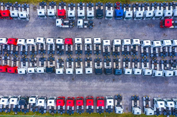 Aerial view of a car distribution centre, new cars parked in rows on a lot ready for sale.