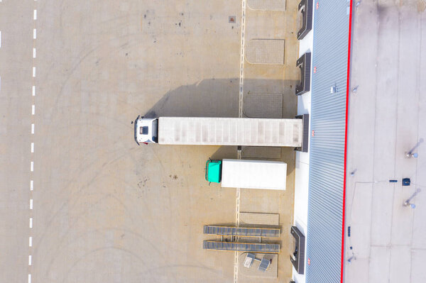 Aerial view of storage and freight terminal with trucks and containers. Industrial background. Logistic center.