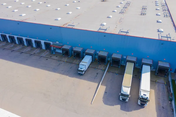 Aerial view of warehouse with trucks. Industrial background. Logistics from above.