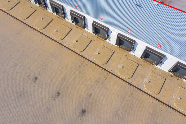 Aerial top view of truck and cargo trailer unloading in logostics center.