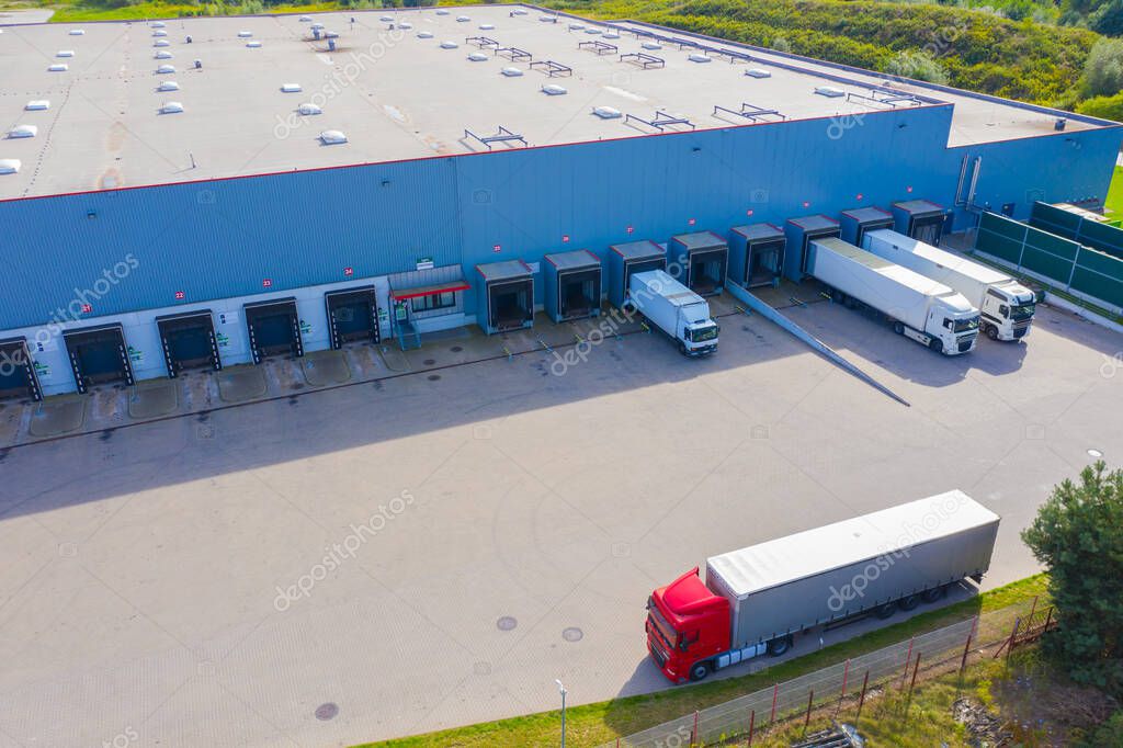 Aerial Shot of Industrial Loading Area where Many Trucks Are Unloading Merchandise.