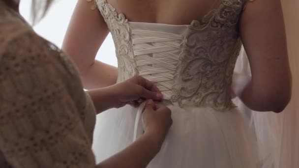 Día de la boda. Dama de honor aprieta corsé de boda — Vídeo de stock