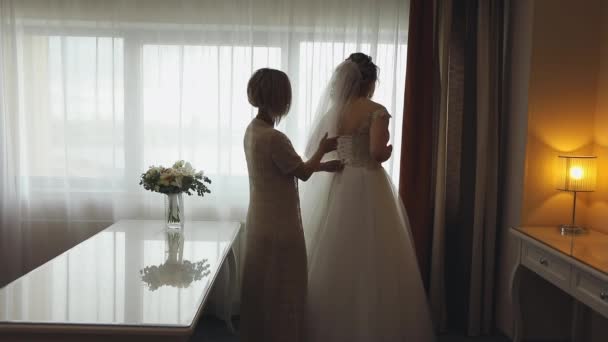 Bridesmaid helps the bride with a wedding dress — Stock Video