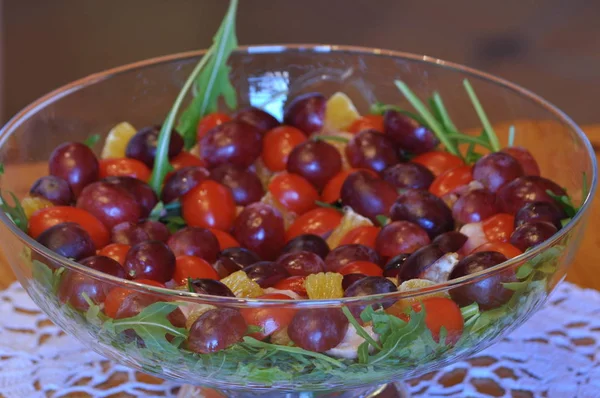 Salad in a glass dish. Rocket salad with grapes.