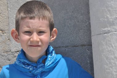 Süt dişleri, bir gömlek ve güneşli bir günde gülüyor bir bandaj ile kasvetli bir çocuk.