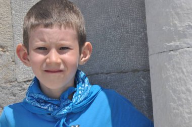 Süt dişleri, bir gömlek ve güneşli bir günde gülüyor bir bandaj ile kasvetli bir çocuk.