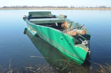 Kürek teknesi kıyıya demirlemiş. Nehirde bahar. Yüzen.