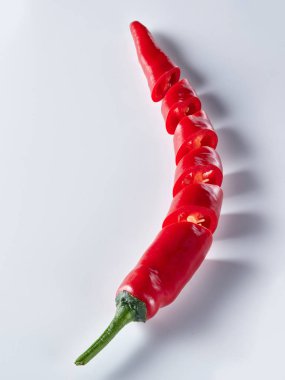  beyaz zemin üzerine kırmızı biber dilimlenmiş
