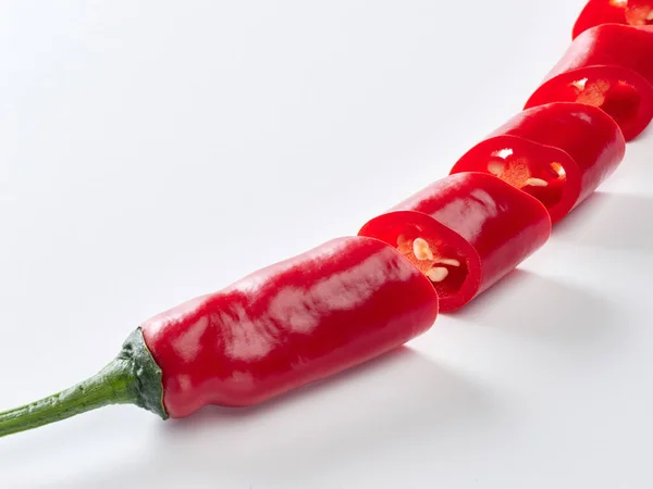  beyaz zemin üzerine kırmızı biber dilimlenmiş