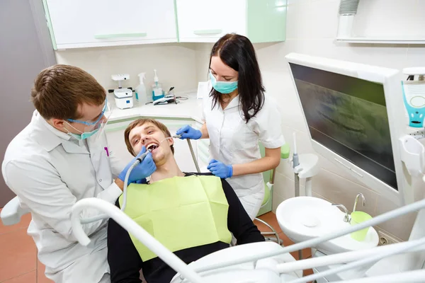 Tandarts Verpleegkundige Maken Professionele Tanden Schoonmaken Jonge Man Patiënt Bij — Stockfoto