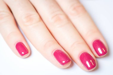 Manikür - güzel yumuşak beyaz havlu üzerinde kırmızı oje ile kadının elleri manikürlü.