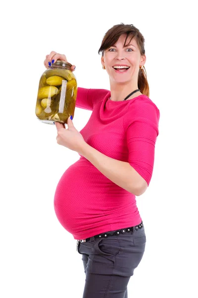 ズボンと赤いブラウスで9ヶ月の幸せで笑顔の妊婦 白い孤立した背景 肯定的な人間の感情 表情上のピクルスとガラス瓶を手に保持 — ストック写真