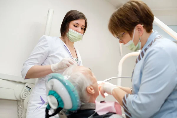 Tandarts Met Verpleegkundige Doen Tandheelkundige Behandeling Van Senior Mannelijke Patiënt — Stockfoto