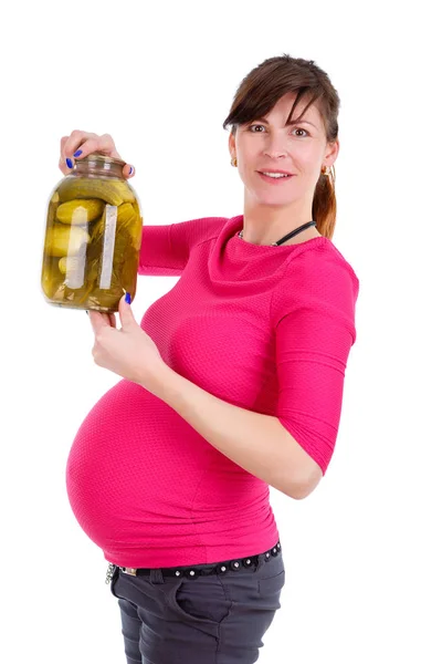 ズボンと赤いブラウスで幸せな妊娠中の女性9ヶ月 白い孤立した背景 肯定的な人間の感情 表情上のピクルスとガラス瓶を手に保持 — ストック写真