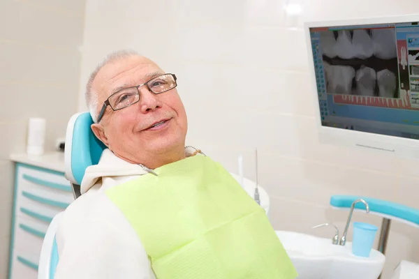 歯科医院に座っている新しい歯科インプラントを持つ笑顔の老人 — ストック写真