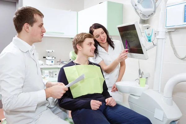 Чоловічий Стоматолог Помічницею Жінки Показує Рентгенівське Зображення Пацієнту Стоматологічній Клініці — стокове фото