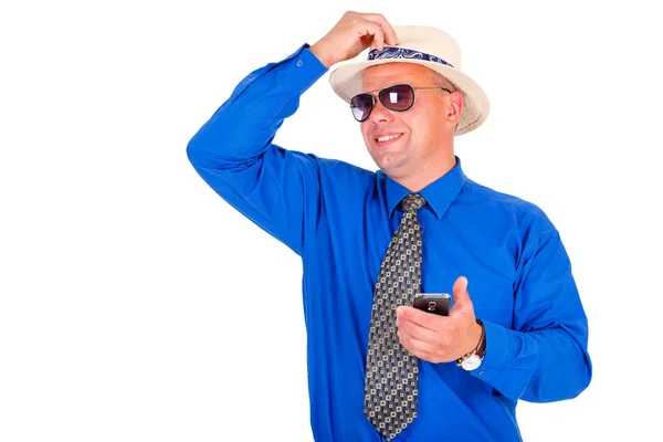 青いシャツ ネクタイ サングラスで成功し 幸せなビジネスマン 携帯電話の携帯電話を手に持ち もう一人の手で頭に白い帽子を固定した 孤立した白 リーダーシップの概念 — ストック写真