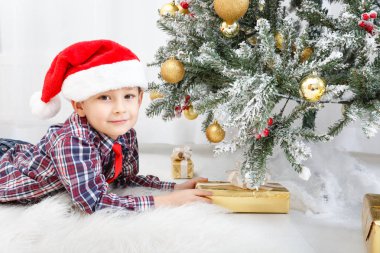 Beyaz Noel ağacı yakınında Noel hediyesi ile çocuk çocuk
