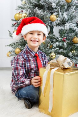çocuk beyaz Noel ağacının yanında hediye kutusu