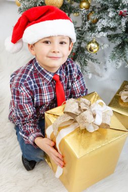 çocuk beyaz Noel ağacının yanında hediye kutusu