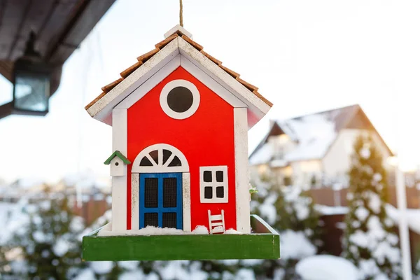 雪に覆われた冬に屋外にぶら下がる赤い色の木製の鳥の家 — ストック写真