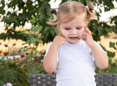 Küçük kız yanaklarına boya bulaşmış..