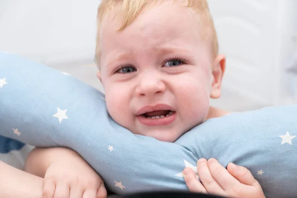 Loira bebê menino chorando abraçando um travesseiro. — Fotografia de Stock