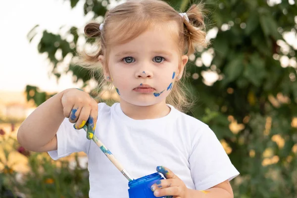 絵具と筆を持ったブロンドの女の子. — ストック写真