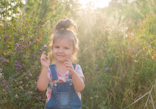 彼女の頭の上に面白いポニーテールを持つ女の子自然界で. — ストック写真