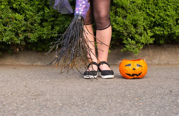 Halloween closeup pernas de bruxa em botas e com vassoura e abóbora. — Fotografia de Stock