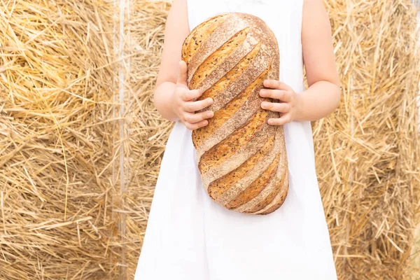Девушка держит в руках экологически чистый натуральный хлеб. — стоковое фото