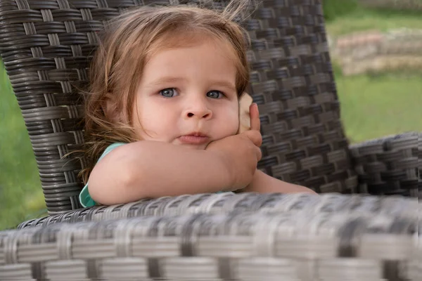 Cute girl sitting in chair calling on toy phone — Stock Photo, Image