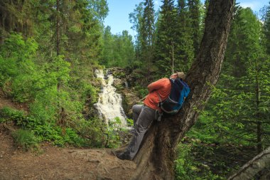 Turist orman şelale yakınında. Gevşeme ve özgürlük hissi.