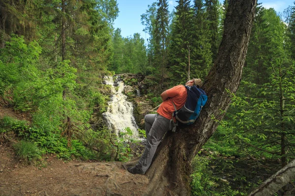 Turist orman şelale yakınında. Gevşeme ve özgürlük hissi.