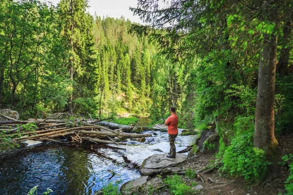 Turist orman şelale yakınında. Gevşeme ve özgürlük hissi.