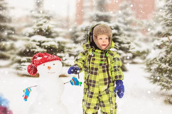 面白い少年は雪だるまと冬の公園 冬の楽しみ 幸せな子供時代 — ストック写真