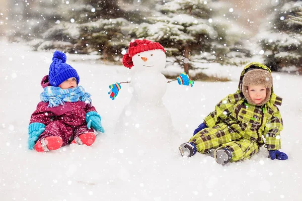 Komik çocuklar kış parkta oynuyorlar. Kış eğlence.