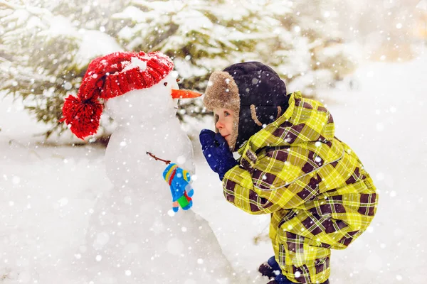 面白い少年は雪だるまと冬の公園 冬の楽しみ 幸せな子供時代 — ストック写真