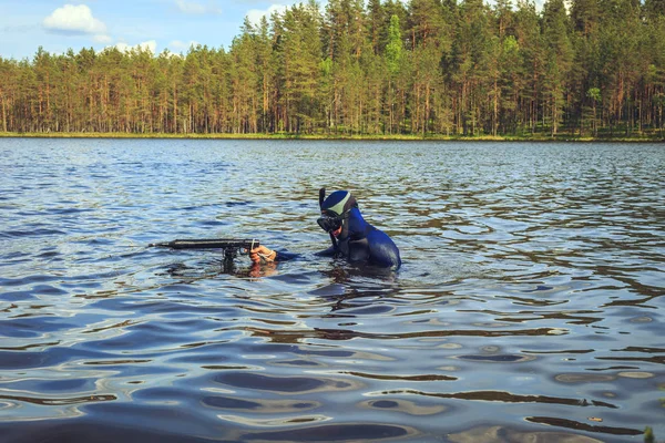 Underwater hunter  preparing to dive. Fishing on a forest lake.
