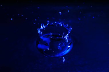 Su damla sıçrama. Renk arka plan, makro, yakın çekim. Seçici odak.