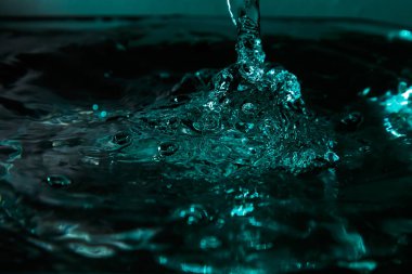 Su damla sıçrama. Renk arka plan, makro, yakın çekim. Seçici odak.